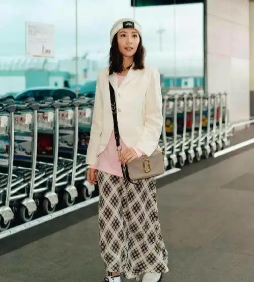  44岁贾静雯机场装嫩,浅色外套搭格子裙,妖娆的自带清纯气息