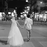  一个黑白情侣头像一个男牵一个女过马路的那女穿着婚纱的